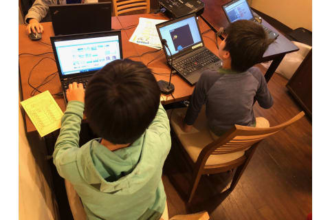 小学生がグループでプログラミングレッスンを受けている様子