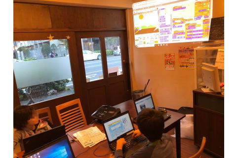 小学生が開発中のスクラッチ作品を他の生徒にプレゼン（説明）している様子