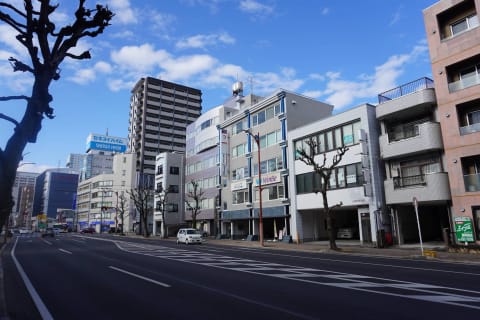 手前の道路が石田街道で、左奥にまっすぐ進むと静岡駅に着きます。壁面に「WinBe」「HALLO」の看板がついた建物の3階です。