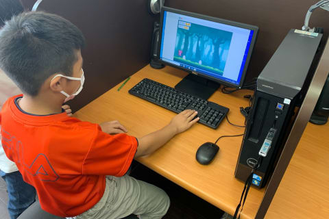 【プライマリーコース】入門編のクラスで、プログラミングに親しむ小学生。夢中になっているのは、ご覧の通り！　思わず立ち上がって操作しています（みなみ野教室）