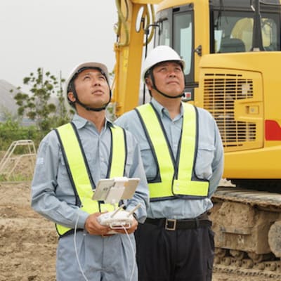 工事現場でドローンを飛ばす作業員