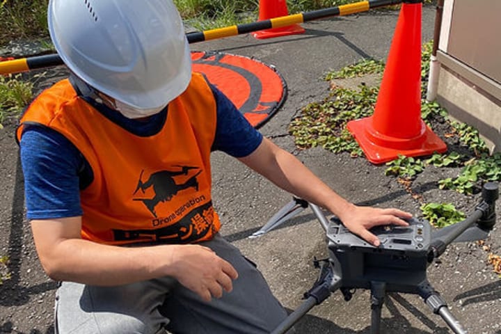 ドローンを整備する男性