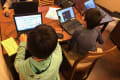小学生がグループでプログラミングレッスンを受けている様子
