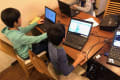 小学生がグループでプログラミングレッスンを受けている様子