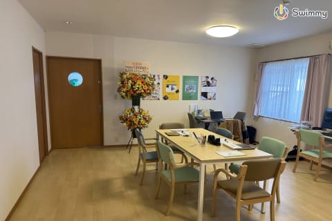 広々とした空間で、木のぬくもりを感じるデスクとカラフルな椅子が並ぶ、清潔感あふれる教室です。