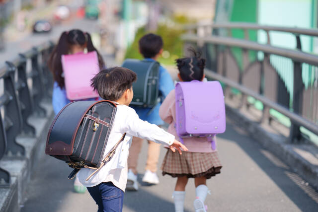小学生が仲間と駆け抜けていく後ろ姿