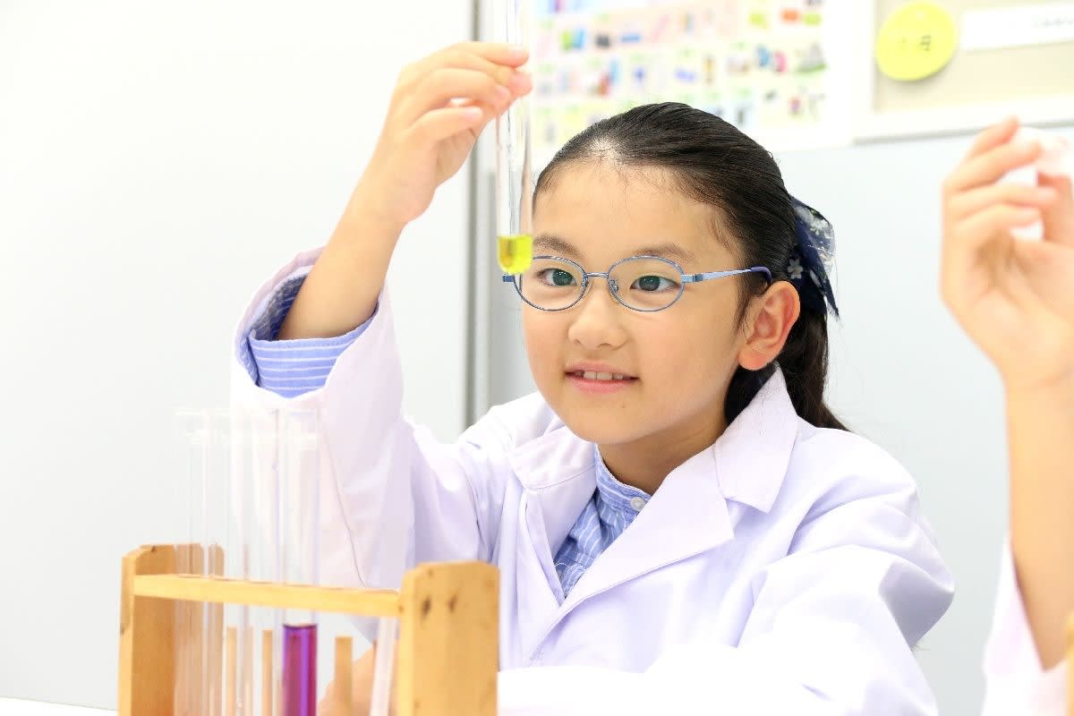実験室で実験をしている眼鏡をかけた少女