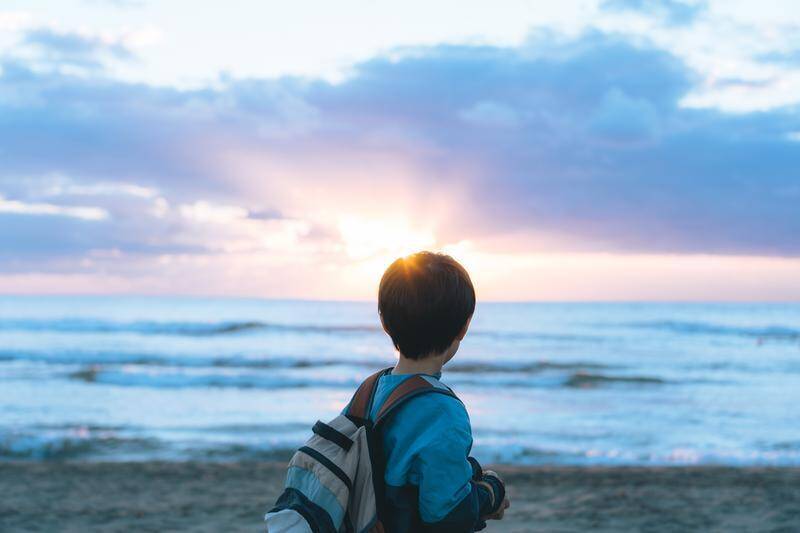 朝日を見つめる少年の姿