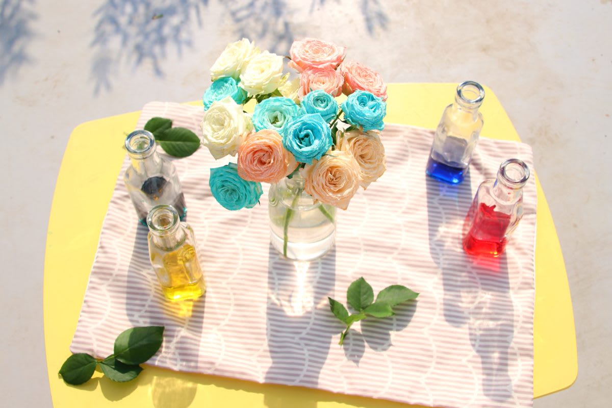 生花がカラフル色づいて一つの花瓶に入れられた様子。