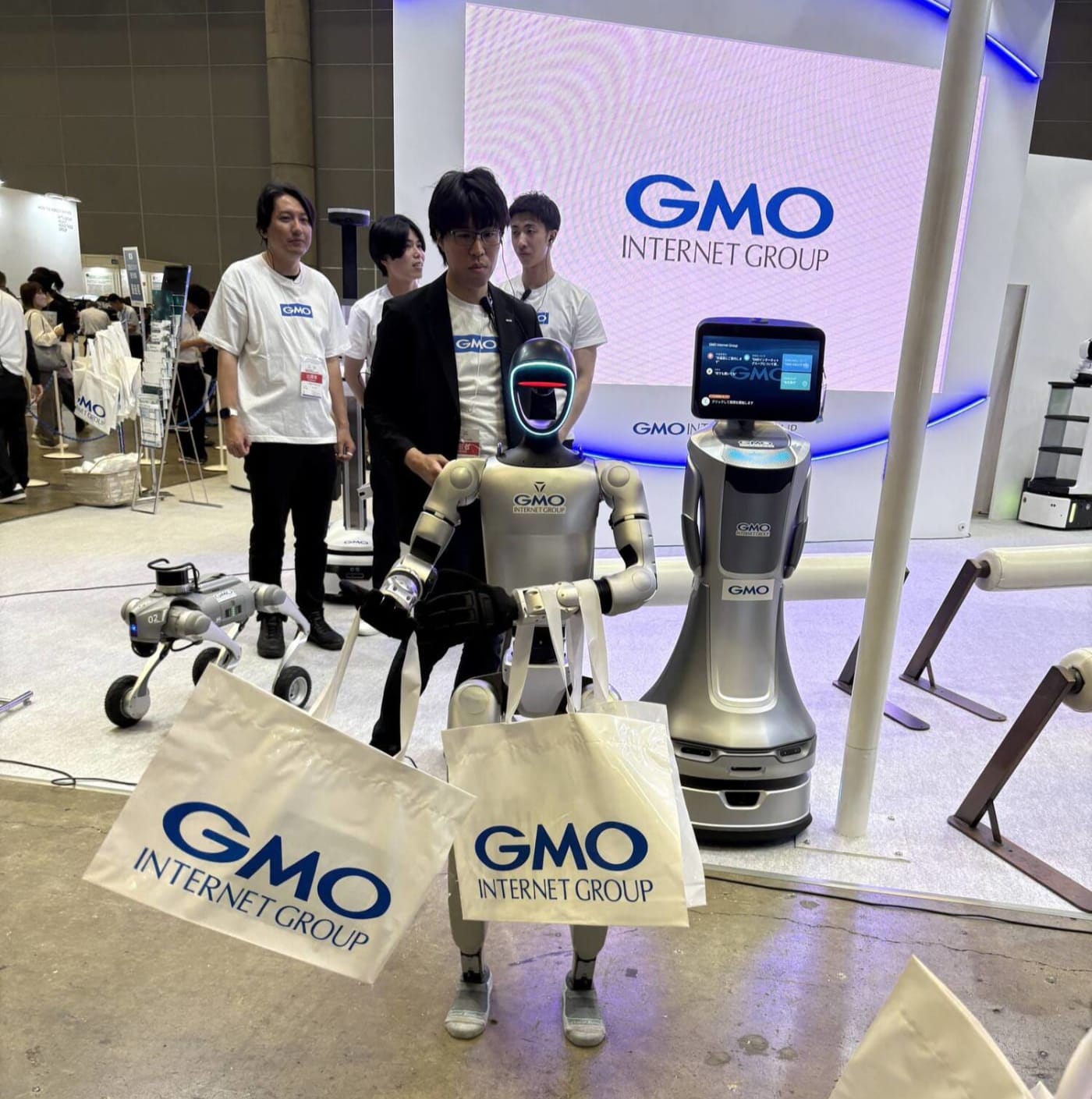 GMOによる小型ヒューマノイドロボットが資料を配布している写真
