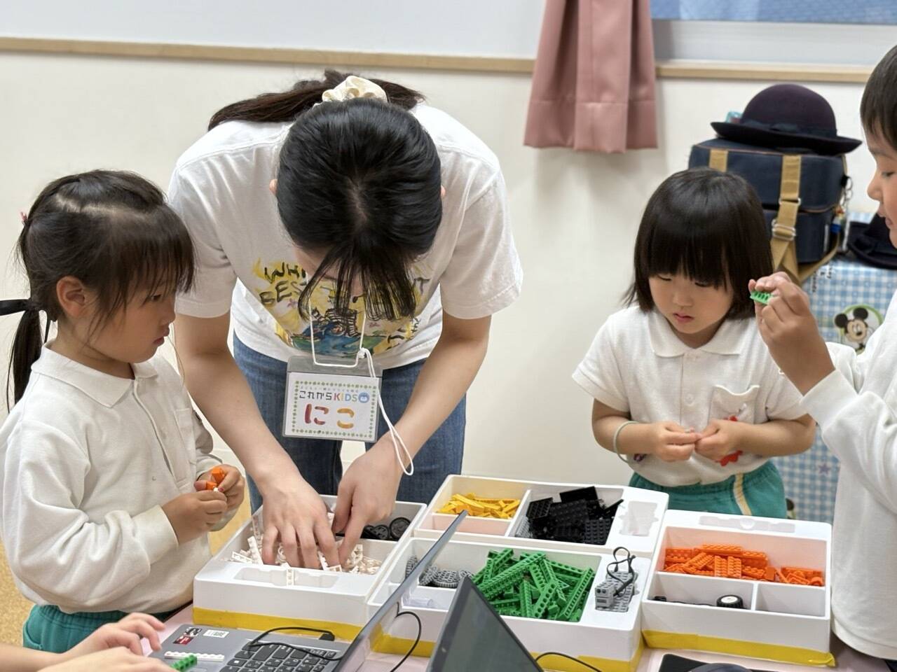 生徒が先生と一緒にブロックのパーツを選んでいる