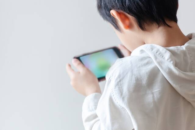 ゲームをする小学生男子の写真