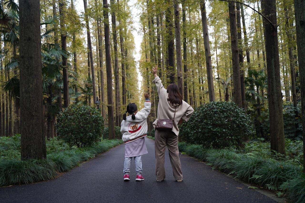 共に歩く親子の後ろ姿の写真