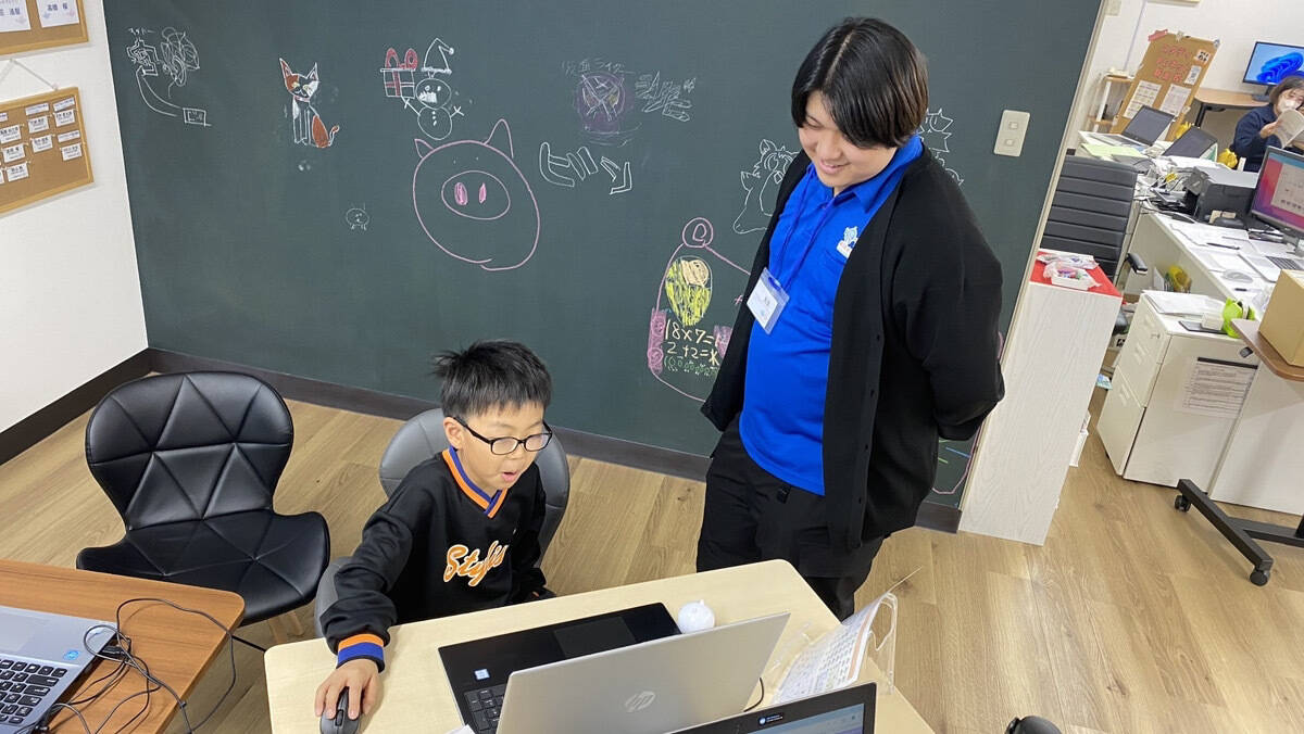 デイサービス職員と一緒にプログラミングを楽しむ様子