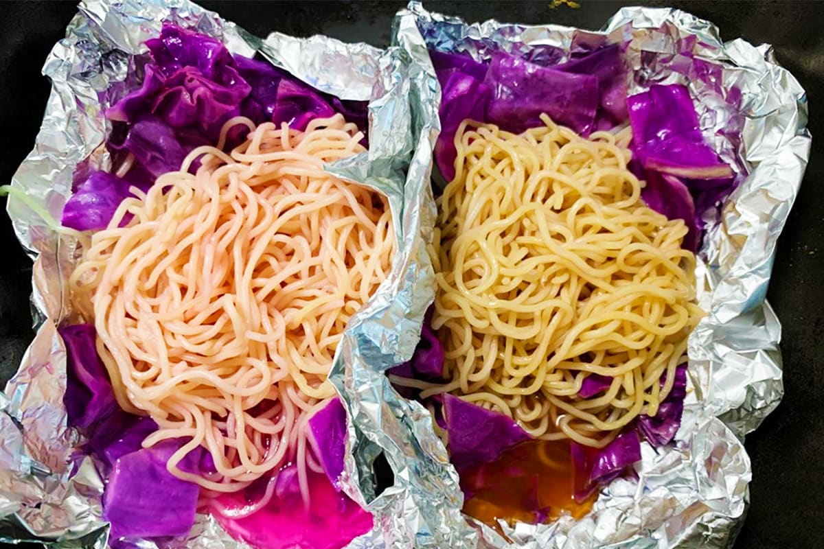 紫キャベツとアルミホイルに包まれた麺の色がそれぞれ変化した様子