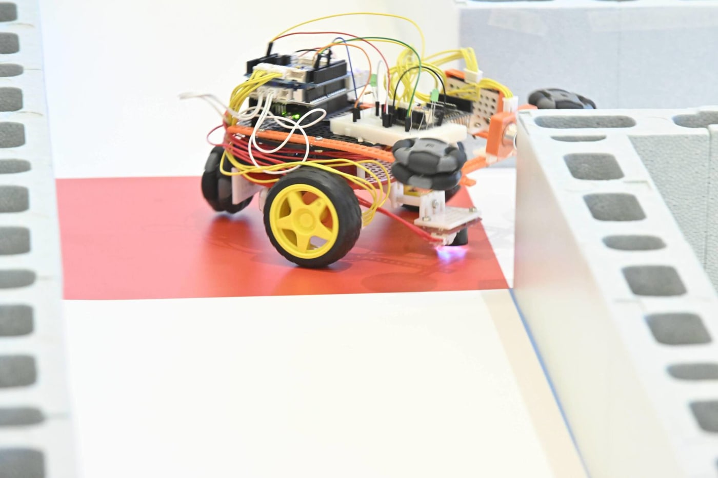 クリエイティブロボティクスコンテスト2025のアタックレースでコーナーを曲がりきれないロボットの写真