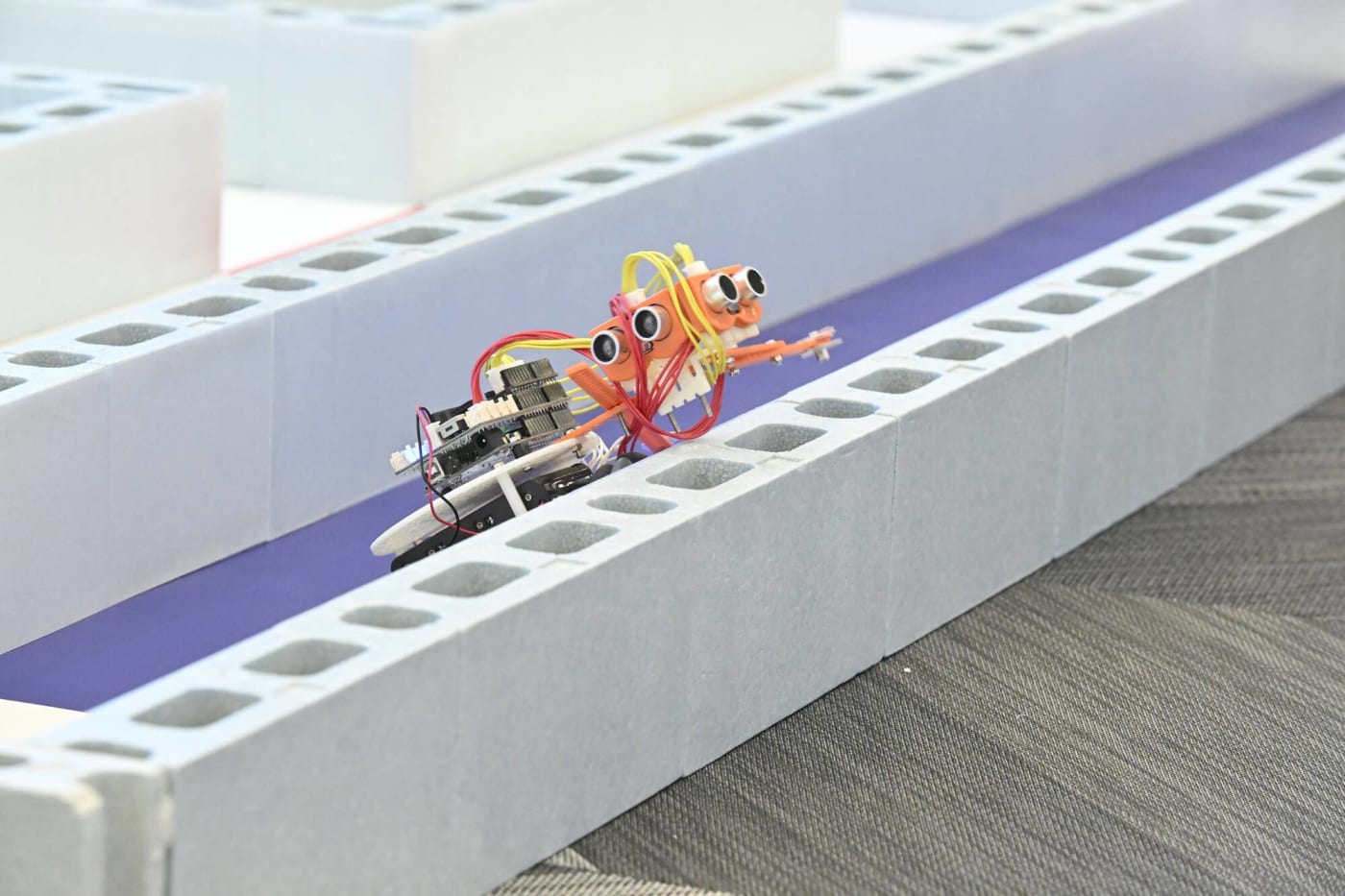 少しずれると壁にあたり方向転換がうまくいかない…クリエイティブロボティクスコンテスト2025のアタックレースで壁にのりあげるロボット