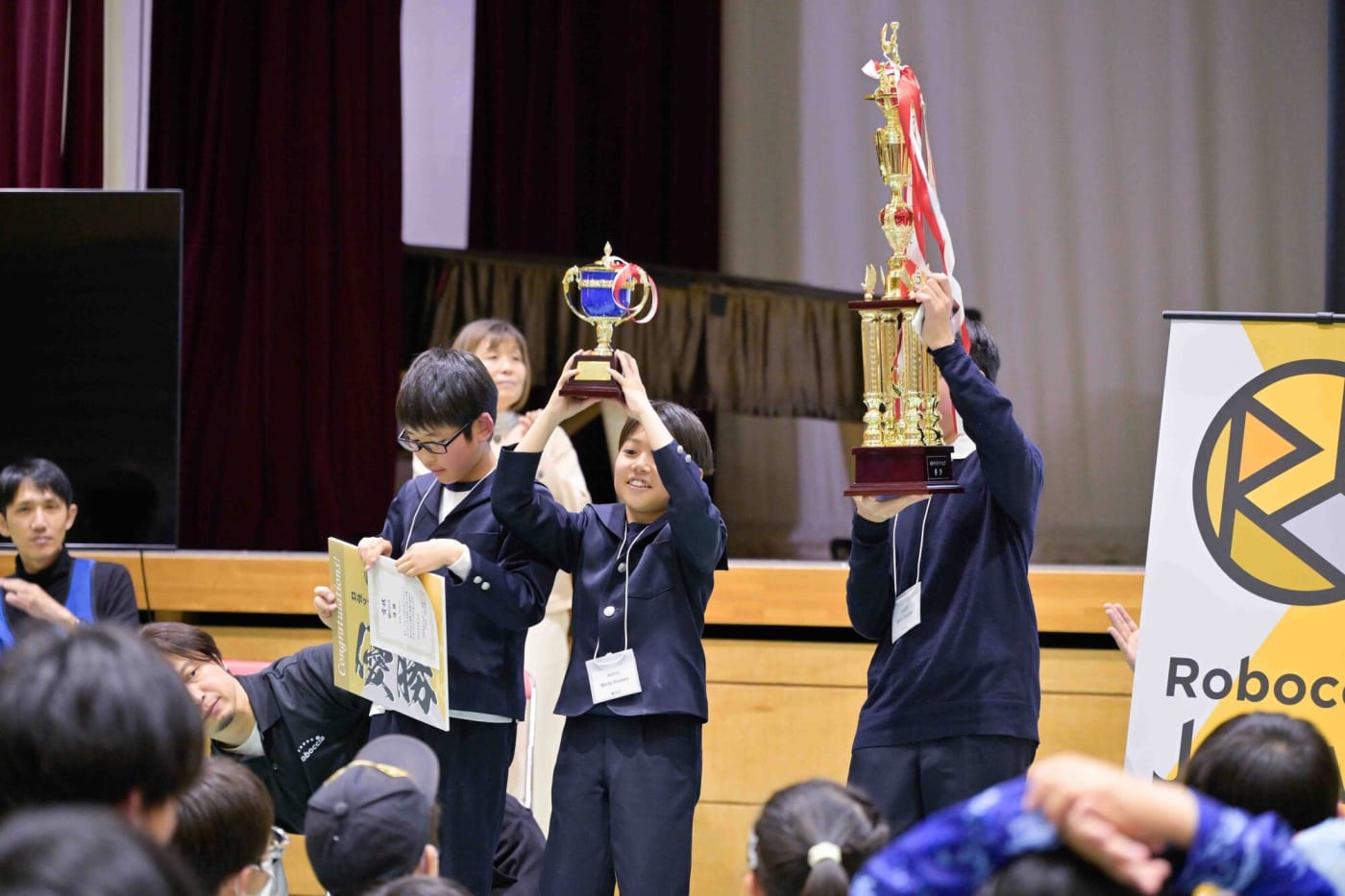 トロフィーを高く掲げ、喜びを分かち合う優勝チームのMecha Shooters(群馬・Felice Tamamura International School)
