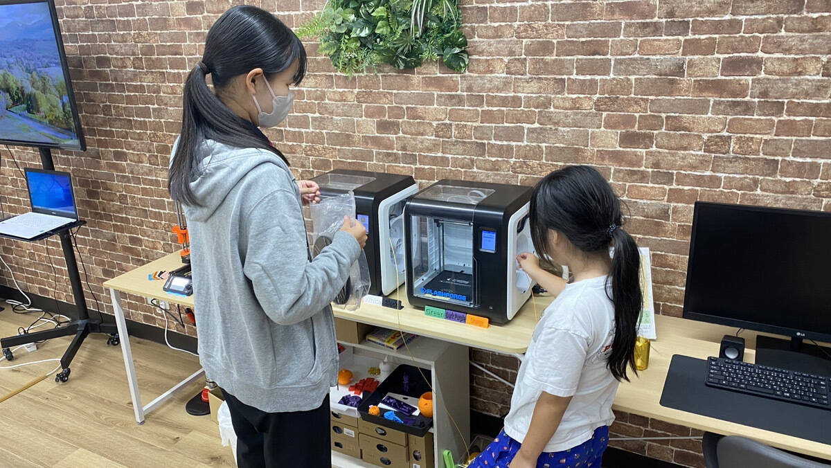 教室の仲間と一緒に3Dプリンターを使用している様子