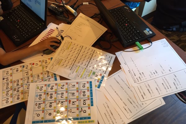 小学生が設計書を書きながらスクラッチでゲーム作りをしている様子