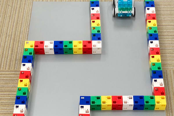 KOOVレギュラーコースの体験会では、ロボットカーを組み立ててクランク型(ジグザグ)のコースに挑戦。どう動けばゴールできるかを考え、自分でプログラミングして試します。【2025年6月更新】