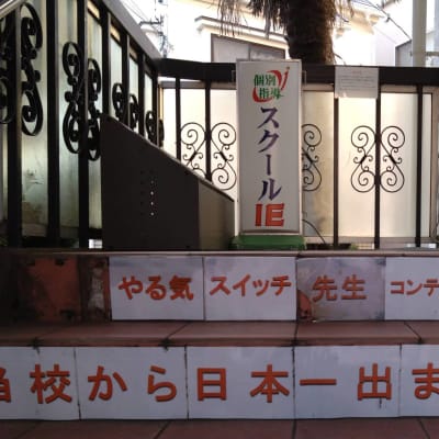 建物の左側にある階段を上って2階へお越しください。