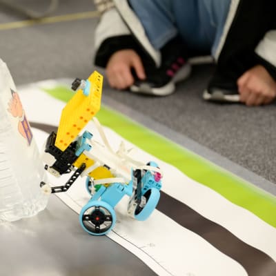 ブロンズコースの競技は「ライントレース相撲」です。  各自が工夫を凝らしたロボットを用いて、フィールドを一周したら真ん中に置かれた「お相撲さん」に見立てられたペットボトルを倒します。