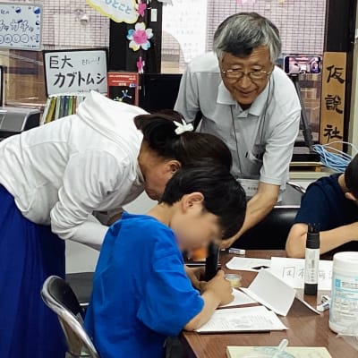 簡易顕微鏡でゾウリムシをのぞいています。スペースに余裕があるときは，保護者の方が一緒に参加されることも。