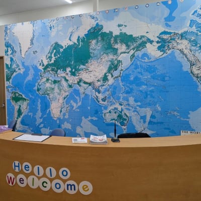 受付にてお出迎えいたします。 受付向かって右側がスクールIE、左側にチャイルド・アイズ、WinBeの教室があります。