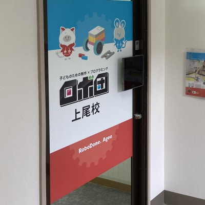 教室入口です。ハロウィンやクリスマスなど季節によって装飾が施してあります。またご自由にお使いいただける塗り絵用紙が置いてあります！