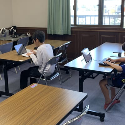 3人レッスン風景。広々とした教室で真剣に学習しています。