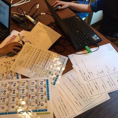 小学生が設計書を書きながらスクラッチでゲーム作りをしている様子