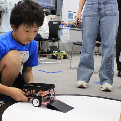 Robo RAVE での大会の様子。こちらのロボットは、手前に坂を作ることで、相手のロボットの車輪を乗り上げさせて持ち上げやすくする工夫をしています。【2023年10月撮影】