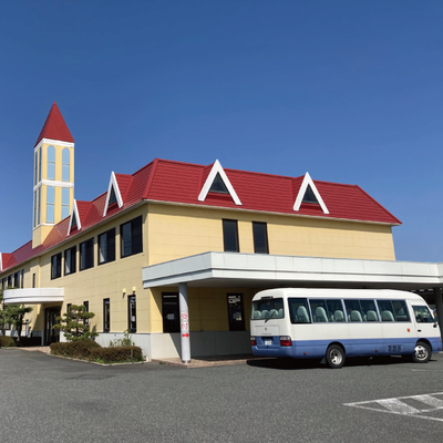 校舎外観。赤い看板と赤い屋根が目印です。入口は赤い看板からです。