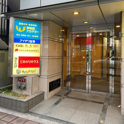一つ目の信号の横断歩道を直進方向に渡ると1階に「ソフトバンク」さんがあるビルがございます。ビルを右手に直進すると「三井住友銀行」さんのATMがございます。その左隣の扉がビルの入り口です。
