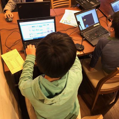 小学生がグループでプログラミングレッスンを受けている様子