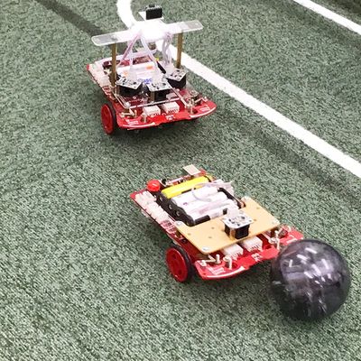 自分で作ったサッカーロボットで他の生徒と対決！センサーでボールを認識し、相手のゴールに向けて動かせるようにプログラミングします。相手の動きを見ながら調整できるかもポイント。【2024年4月撮影】