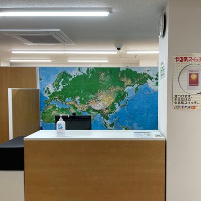 受付はこちらです（階段を上って左手に入口の扉があります）