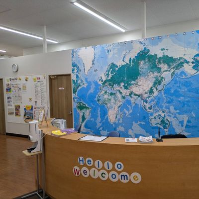 受付にてお出迎えいたします。 受付向かって右側がスクールIE、左側にチャイルド・アイズ、WinBeの教室があります。