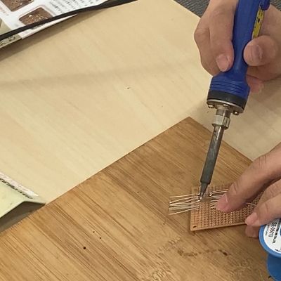 「はんだごて」を使った部品の接着、火傷をしないように細心の注意を払って作業が進みます。【2023年6月撮影】