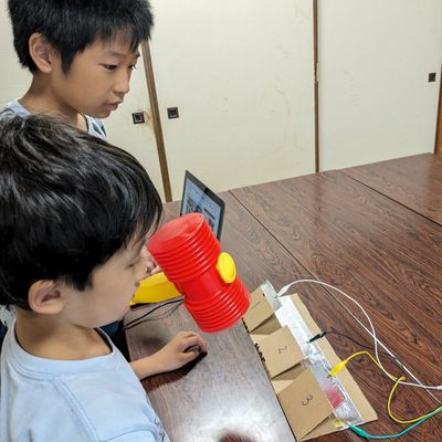 自作のもぐらたたきで遊ぶ子ども達