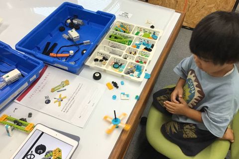 幼稚園クラスの様子です。小型のロボット教材であるレゴ® WeDo2.0を使って、車などのロボットを作成してタブレットでプログラミングします。