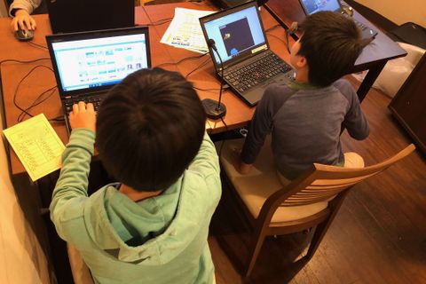 小学生がグループでプログラミングレッスンを受けている様子