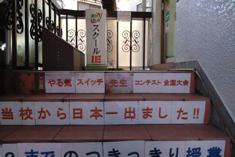 建物の左側にある階段を上って2階へお越しください。