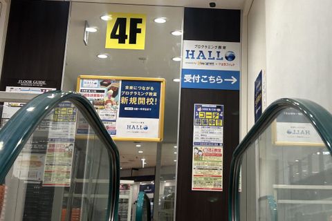 一階入口右手に在るエスカレーターでお上がり下さい。