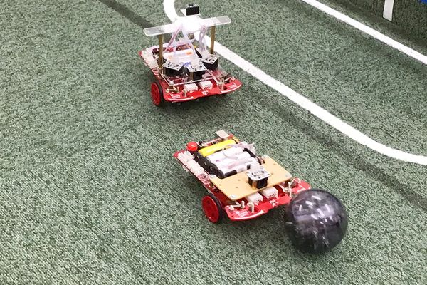自分で作ったサッカーロボットで他の生徒と対決！センサーでボールを認識し、相手のゴールに向けて動かせるようにプログラミングします。相手の動きを見ながら調整できるかもポイント。【2024年4月撮影】