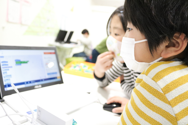 真剣にプログラミングする子供たち