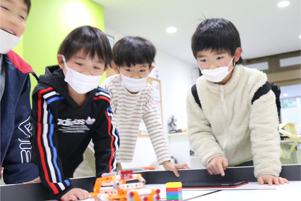 ちゃんと動くかな？プログラミングしたロボットの動きを見守る子供たち