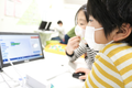 真剣にプログラミングする子供たち