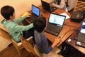小学生がグループでプログラミングレッスンを受けている様子